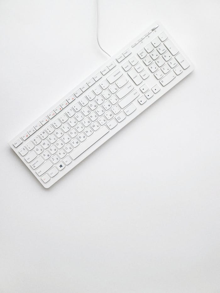 top-view-photo-of-white-keyboard-1772123 A modern white keyboard on a white background showcasing minimalist design and clean aesthetics.